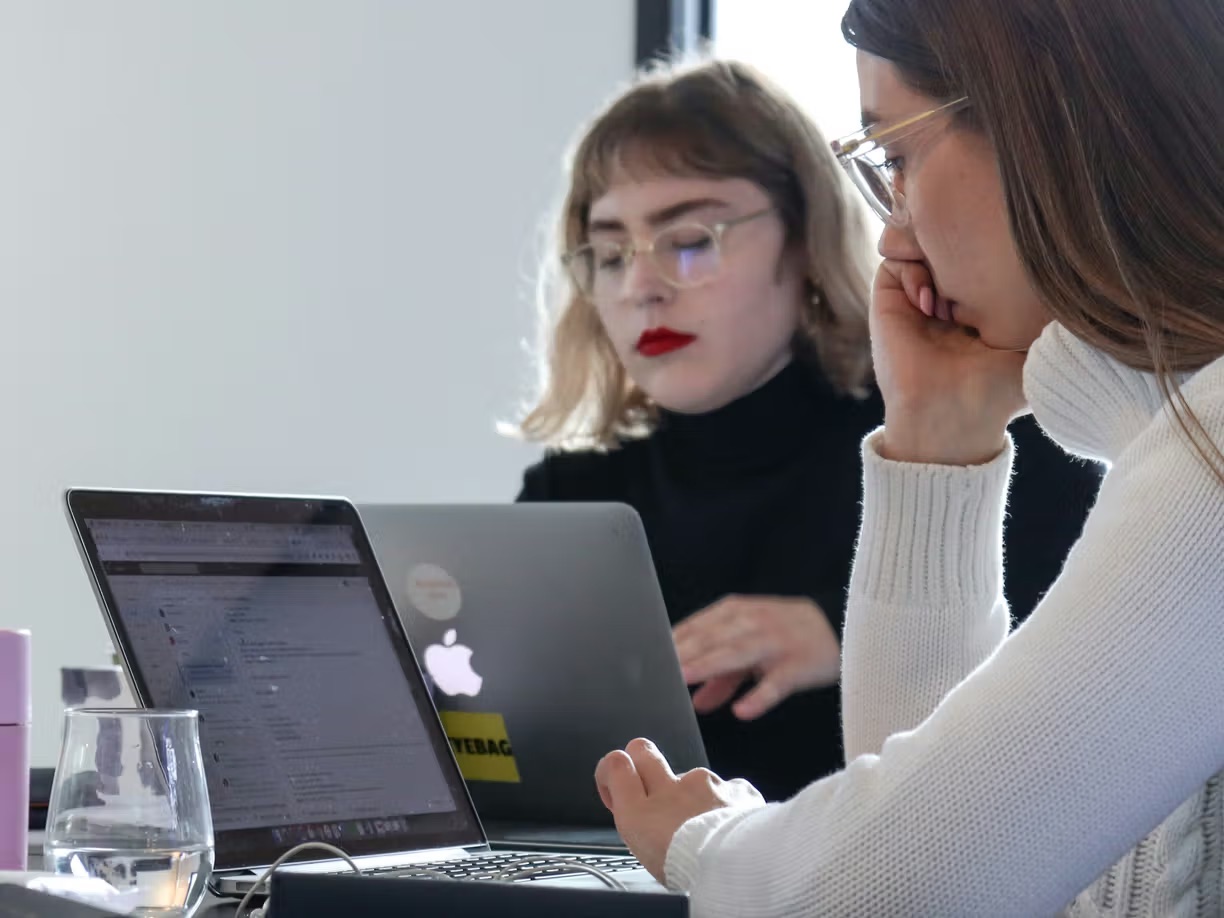 Two colleagues reading the monthly bulletin